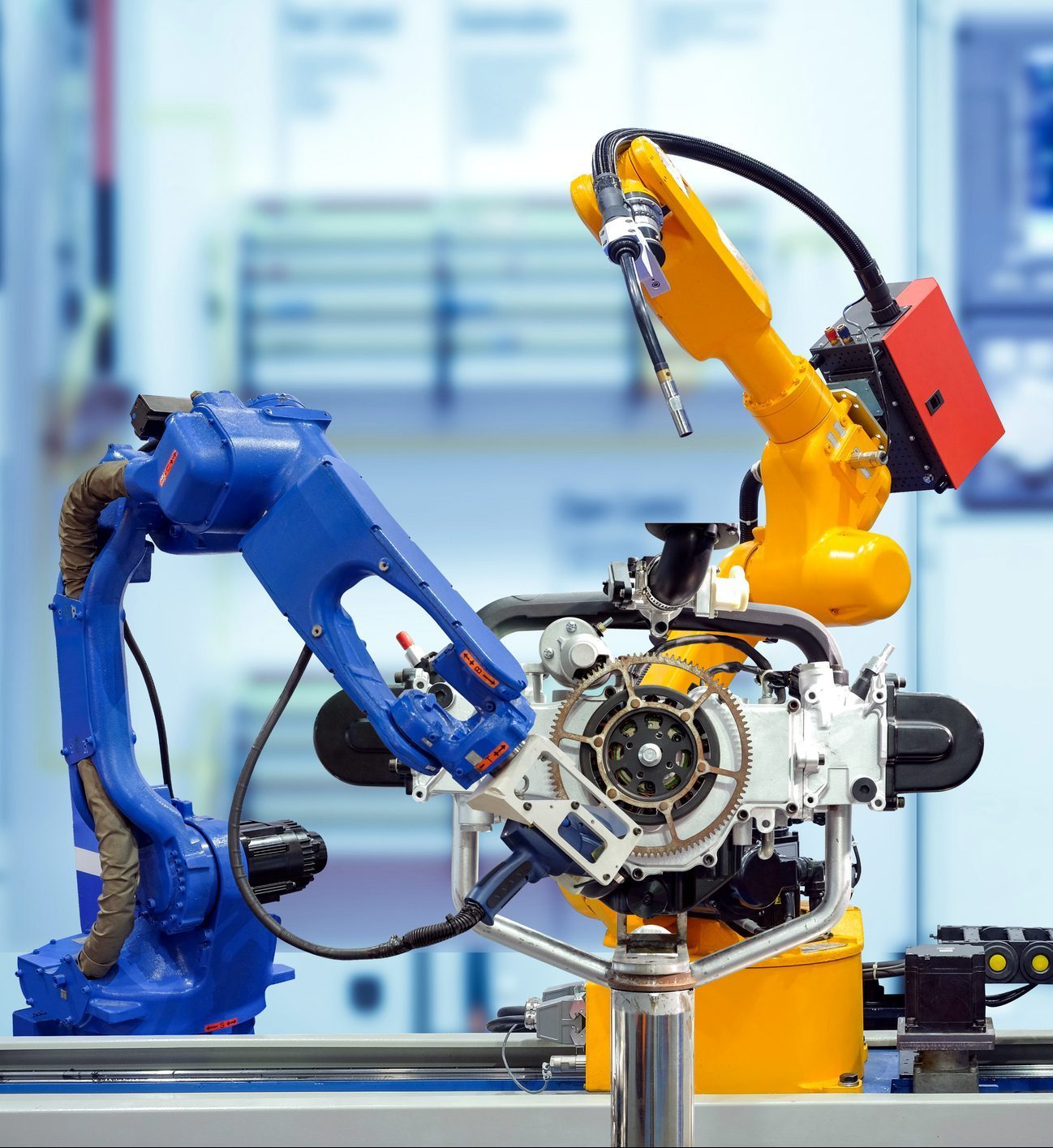 Industrial robotic team working on smart factory Industrial robotic welding and robotic 3D scan working with engine parts on smart factory, on blurred control panel blue tone background, industry 4.0, smart automation working on teamwork concept.